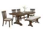 Dining room set with wooden table, chairs, and bench against a stone wall.