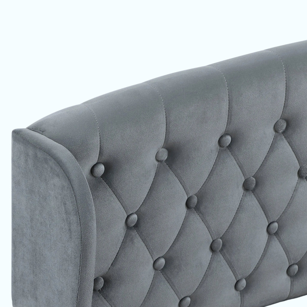 Close-up of a gray upholstered headboard with diamond tufting and button details on a white background.