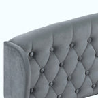 Close-up of a gray upholstered headboard with diamond tufting and button details on a white background.