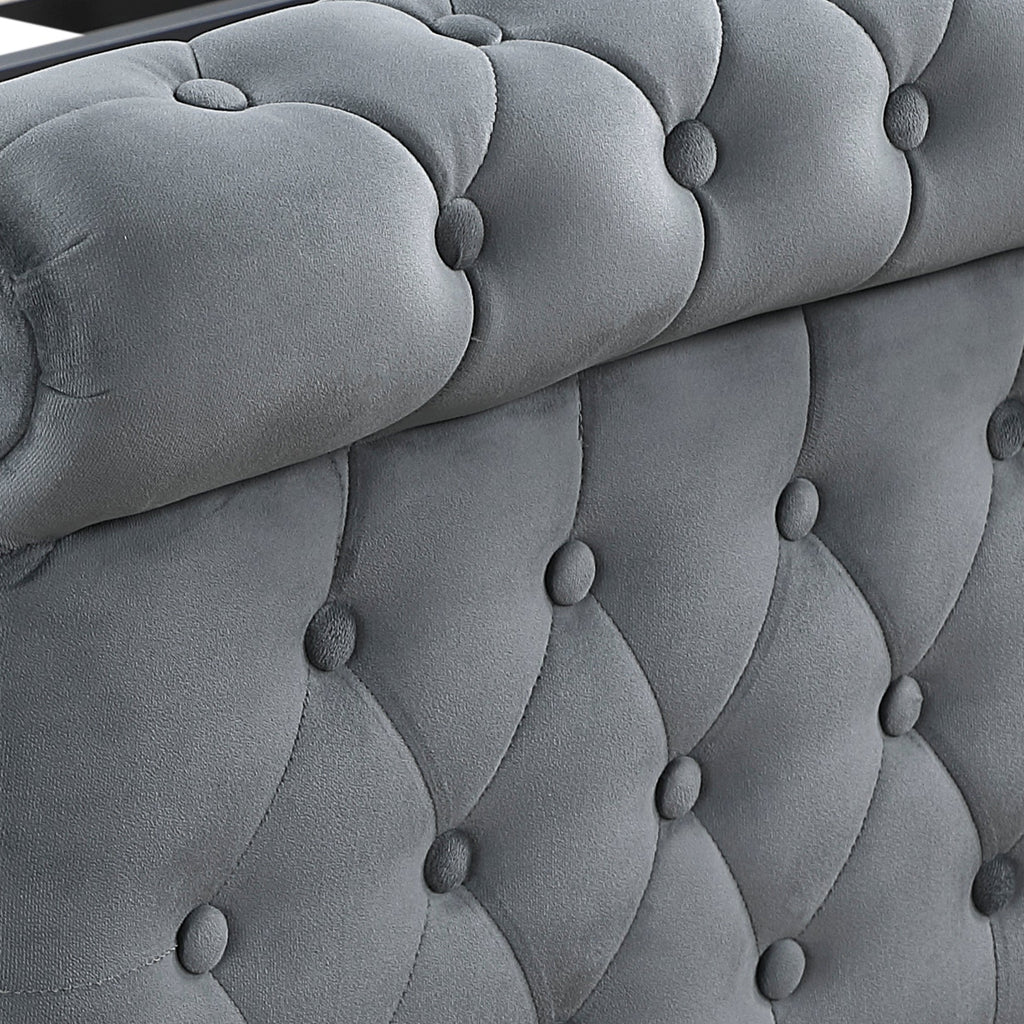 A close-up of a gray tufted velvet bed frame with wooden slats and turned black legs, shown on a white background.
