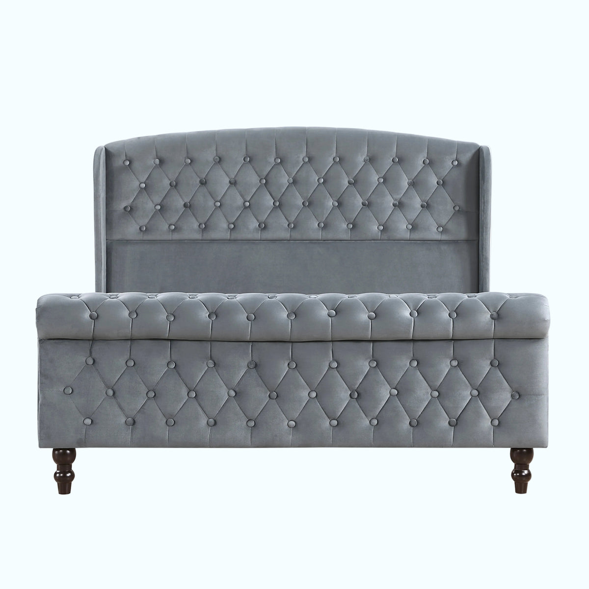 A light gray tufted velvet bed frame with a wingback headboard and matching footboard, supported by dark wooden legs, shown against a plain white background.
