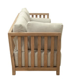 Wooden crib with beige mattress and pillows on a white background