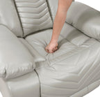 Light gray recliner chair with a person's foot on the seat
