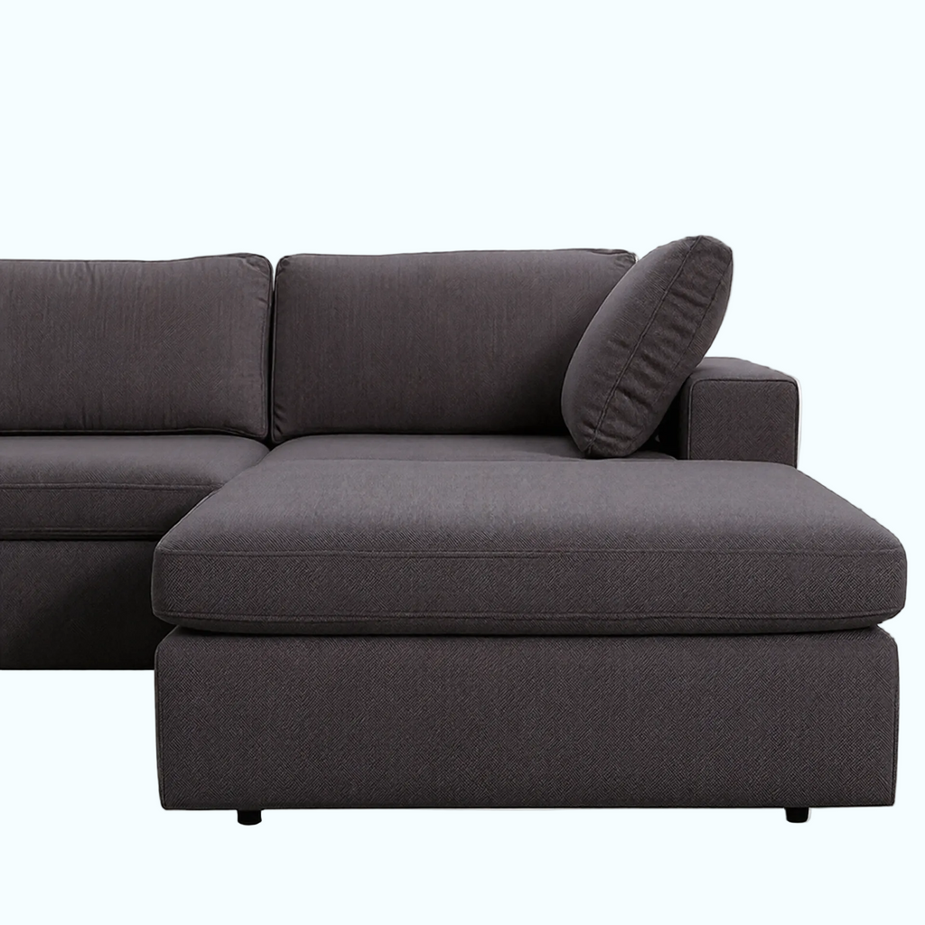 Gray sectional sofa with a pillow on a white background