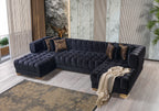 Black tufted sectional sofa in a modern living room with decorative pillows and a rug.