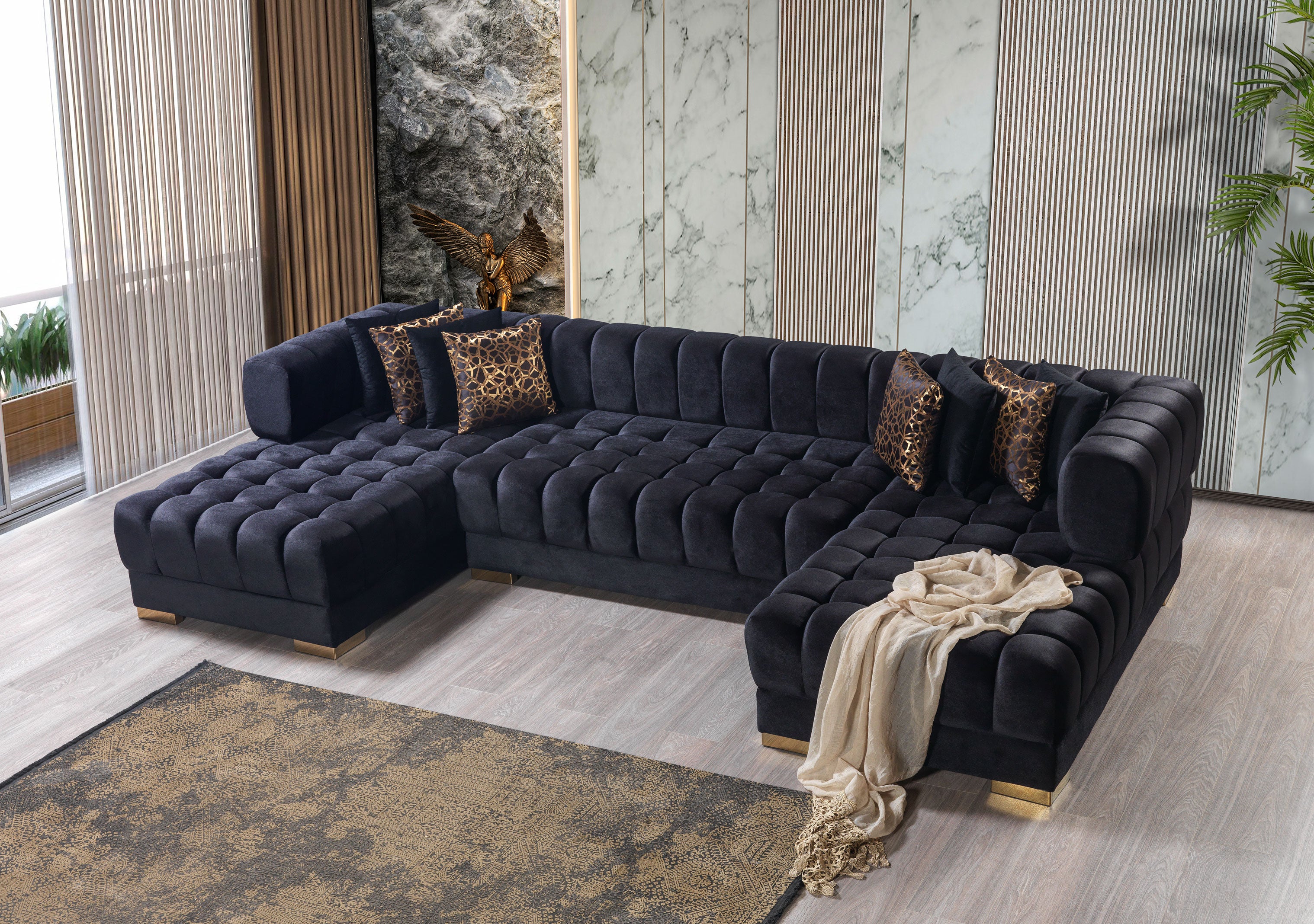 Black tufted sectional sofa in a modern living room with decorative pillows and a rug.