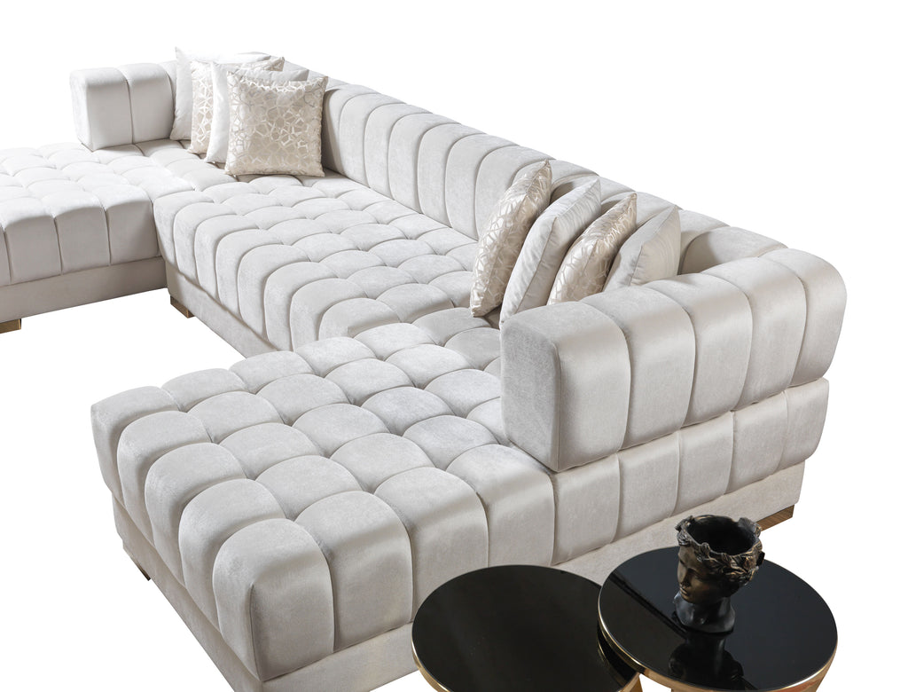 Beige sectional sofa with ottoman and two black round tables on a white background