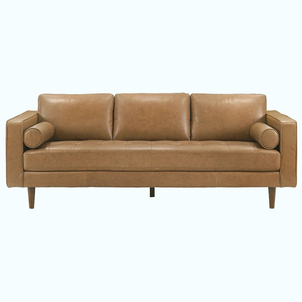 A three-seat leather sofa in a warm tan/camel color, featuring a tufted seat cushion, cylindrical armrests, and tapered wooden legs, shown against a plain white background.