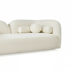 Modern cream-colored sofa with cylindrical design elements on a white background