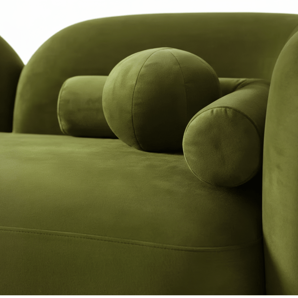 Close-up of a green sofa with rounded cushions on a white background