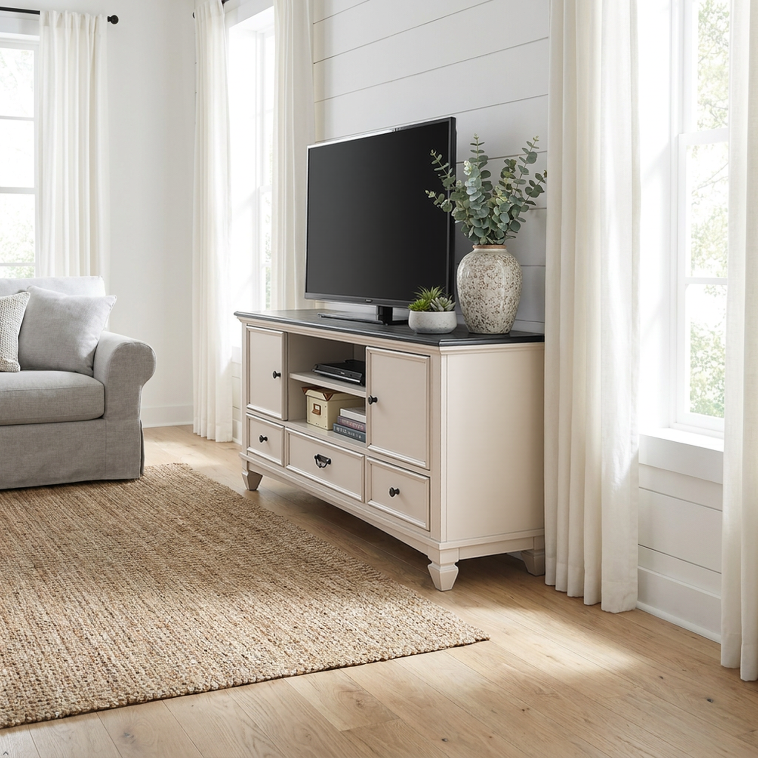 Living room with a white entertainment console, TV, and decor items.