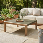 Outdoor patio setting with a coffee table, sofa, and potted plants.