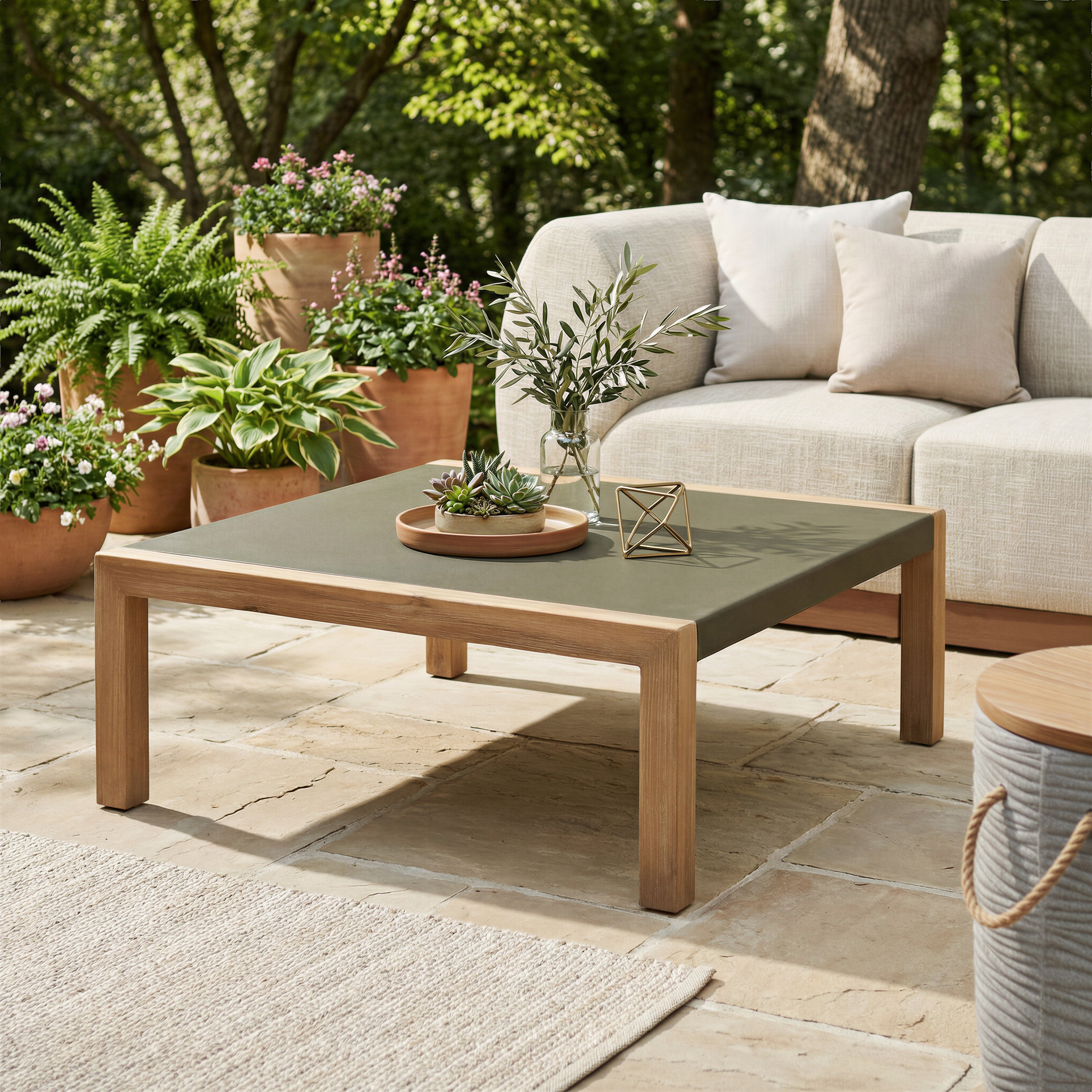 Outdoor patio setting with a coffee table, sofa, and potted plants.
