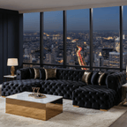 Luxury living room with a black tufted sofa and gold coffee table, overlooking a cityscape at night.