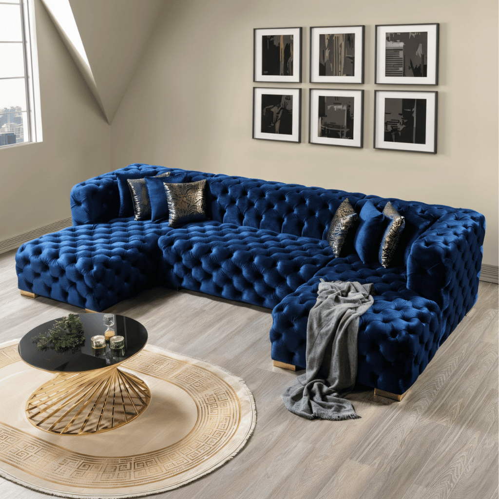 Blue tufted sectional sofa in a living room with decorative pillows and a coffee table.