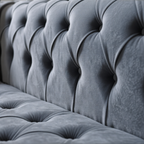 Close-up of a gray tufted sofa
