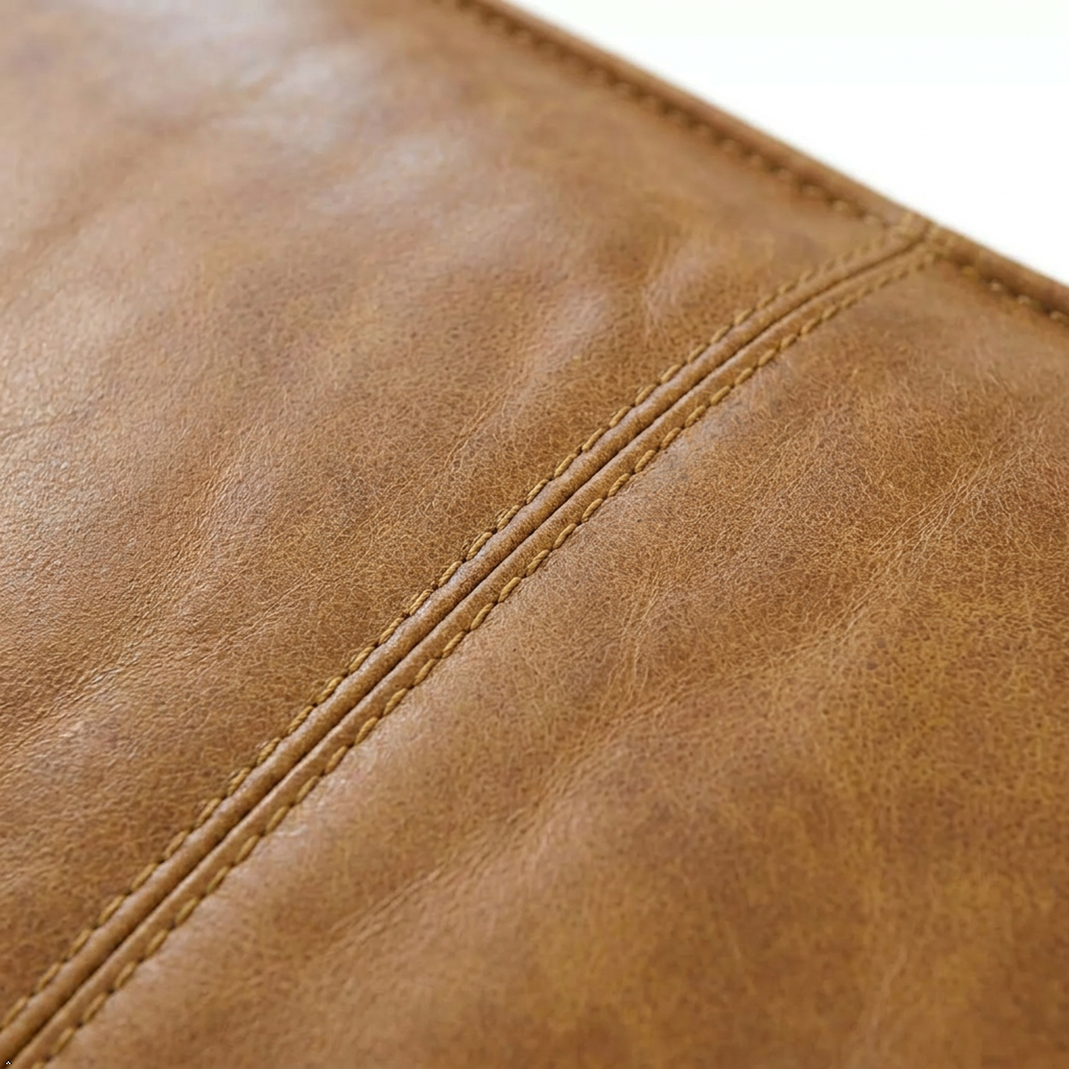 Close-up of brown leather surface with visible stitching