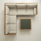 Beige sectional sofa with wooden frame and small table on a white background