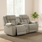 Beige recliner sofa in a living room setting with a plant and window in the background.