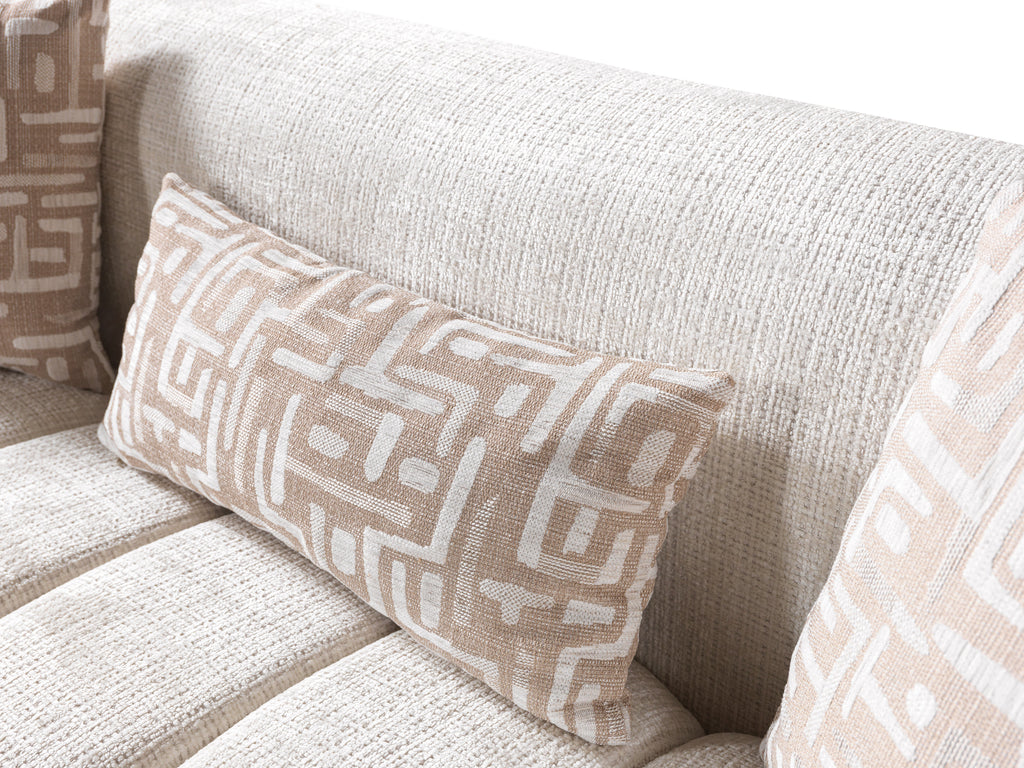 Patterned pillow on a beige sofa with a neutral color scheme