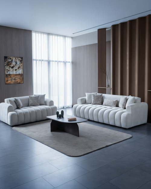 Modern living room with two white sofas, a coffee table, and decorative elements.