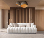 White sofa with patterned cushions in a modern living room with wooden walls and ceiling lights.