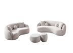 Modern living room with curved white sofas and matching ottomans on a gray rug.