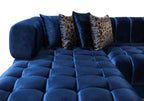 Blue tufted sofa with decorative pillows on a white background