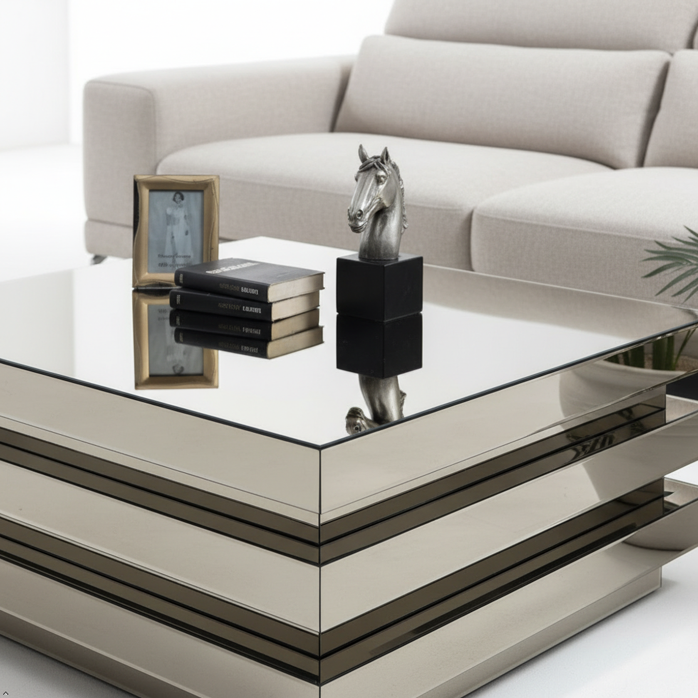 Modern glass coffee table with decorative items in a living room setting
