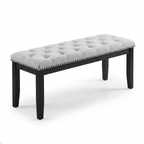 Gray tufted bench with black legs on a white background