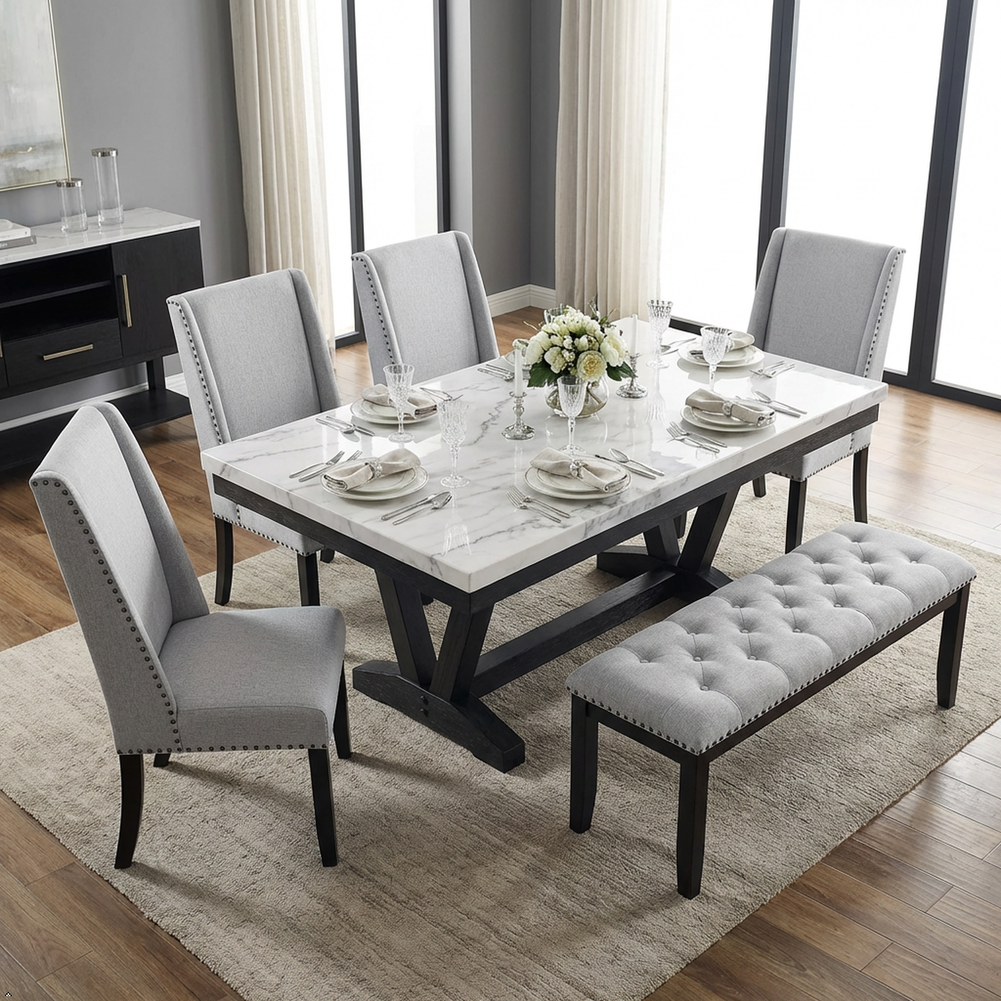 Dining room set with marble table, gray chairs, and bench in a well-lit room.