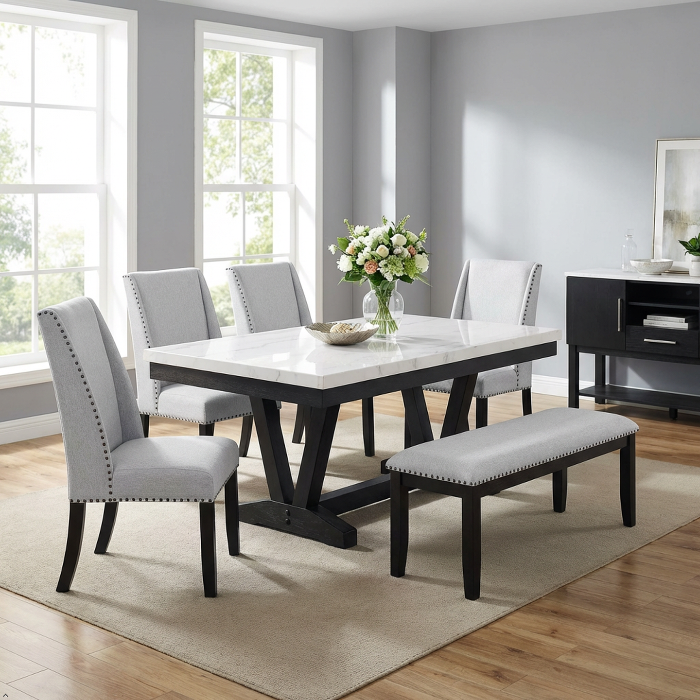 Dining room with a marble table, gray chairs, and a bench.
