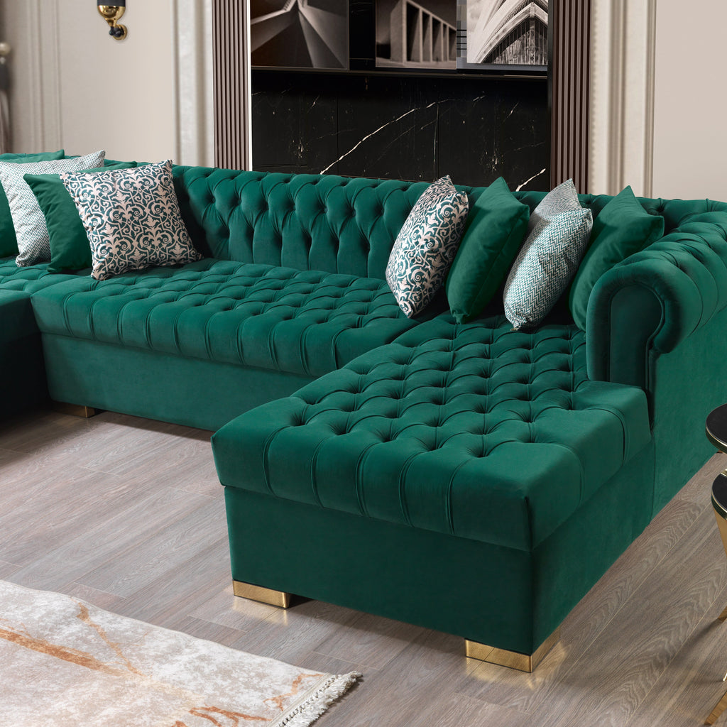 Green velvet sectional sofa with decorative pillows in a living room setting.