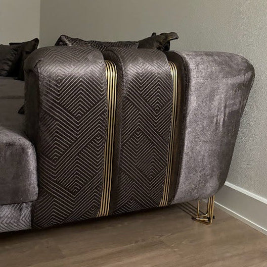 Velvet sofa from side in apartment closeup gold accented arms