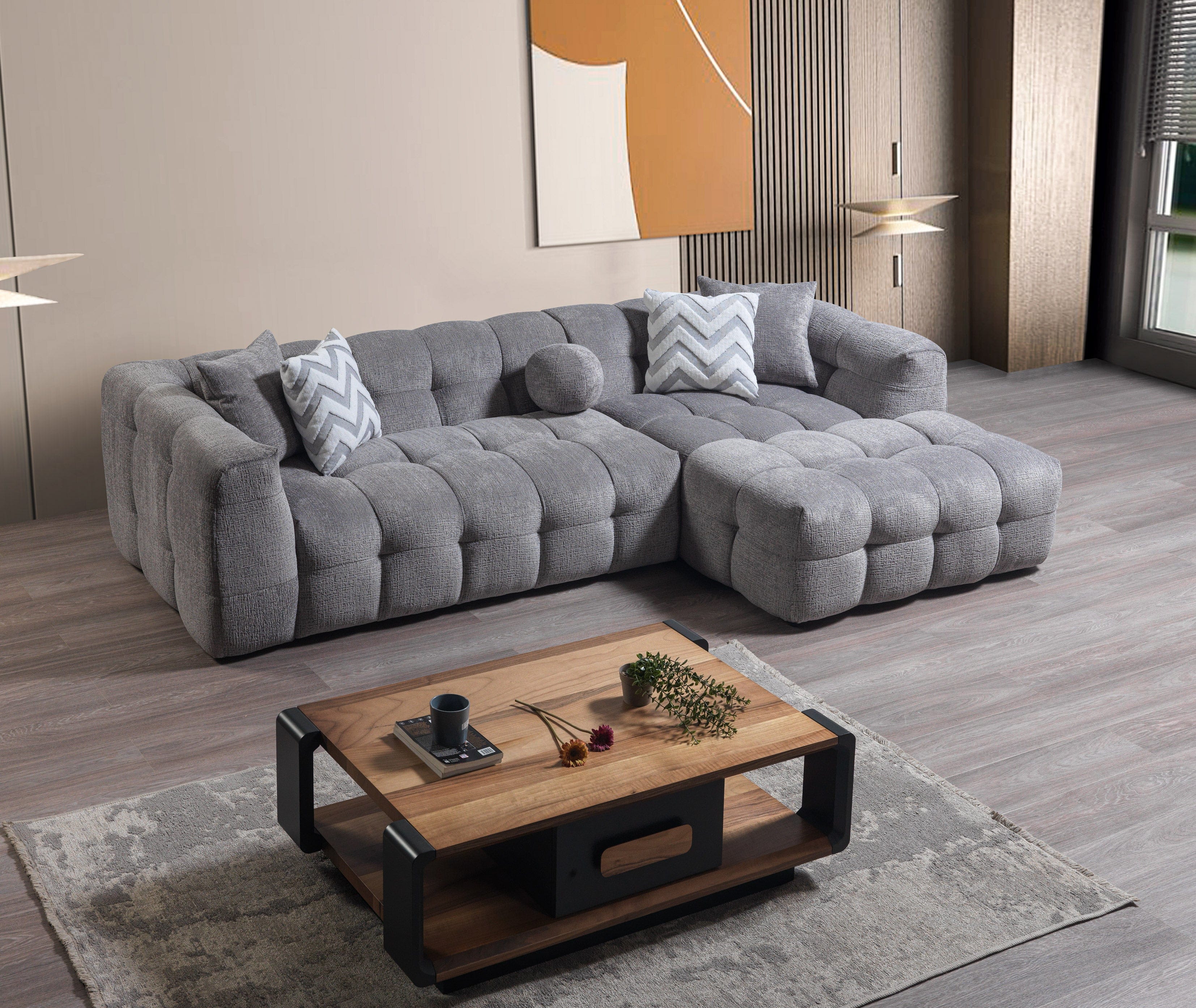 Gray sectional sofa in a living room with a wooden coffee table and decorative items.