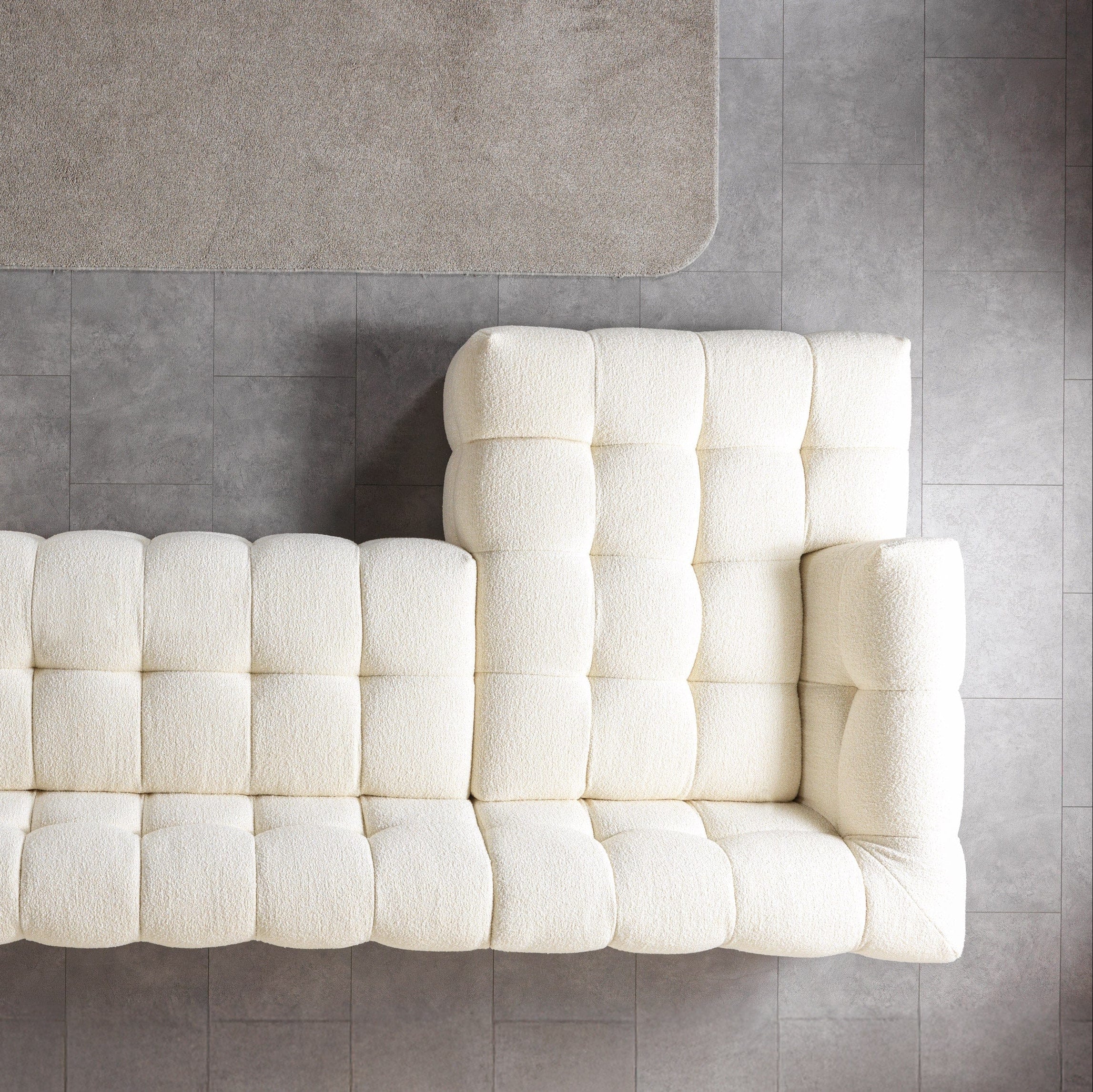 White tufted sofa on a gray floor