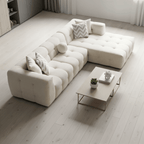 Modern white sectional sofa in a minimalistic living room with a coffee table and decorative items.