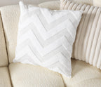 White chevron-patterned pillow on a beige sofa