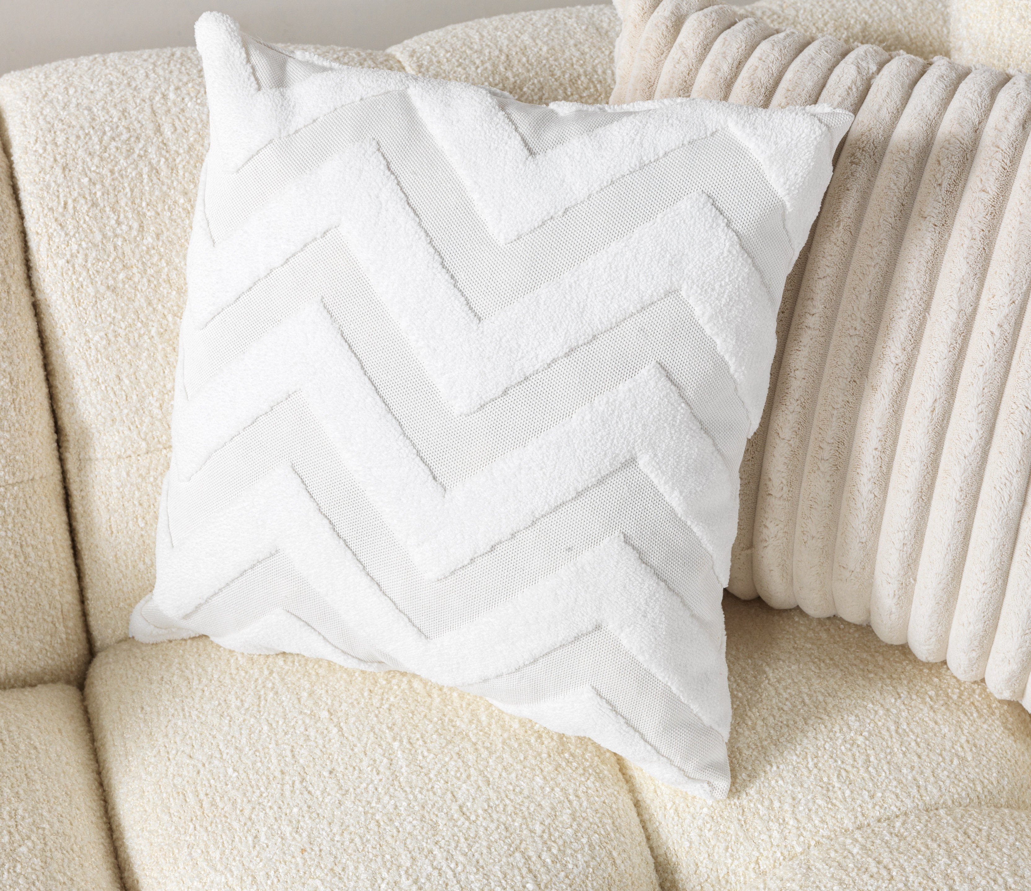 White chevron-patterned pillow on a beige sofa