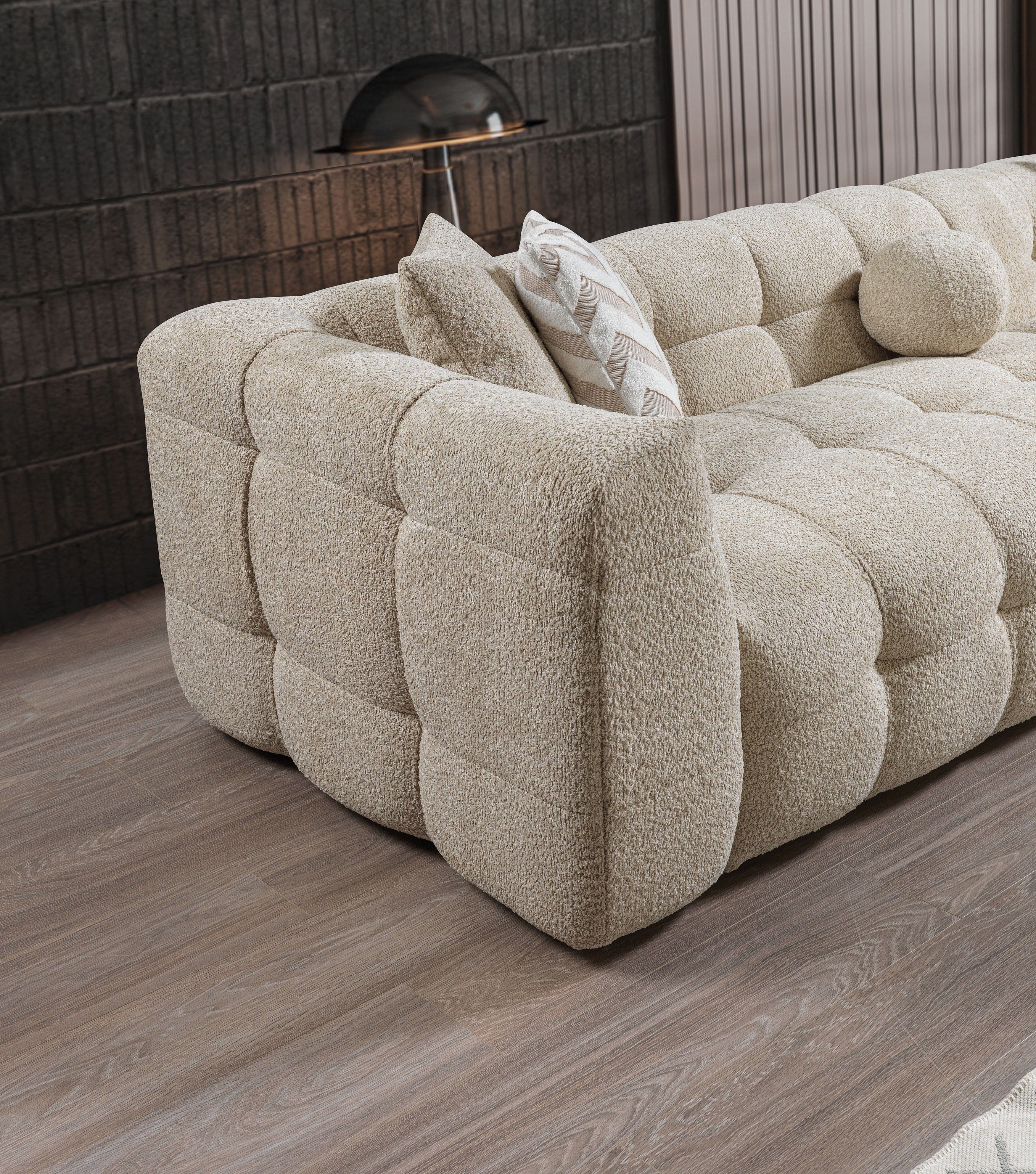 Beige tufted sofa with cushions in a modern room setting