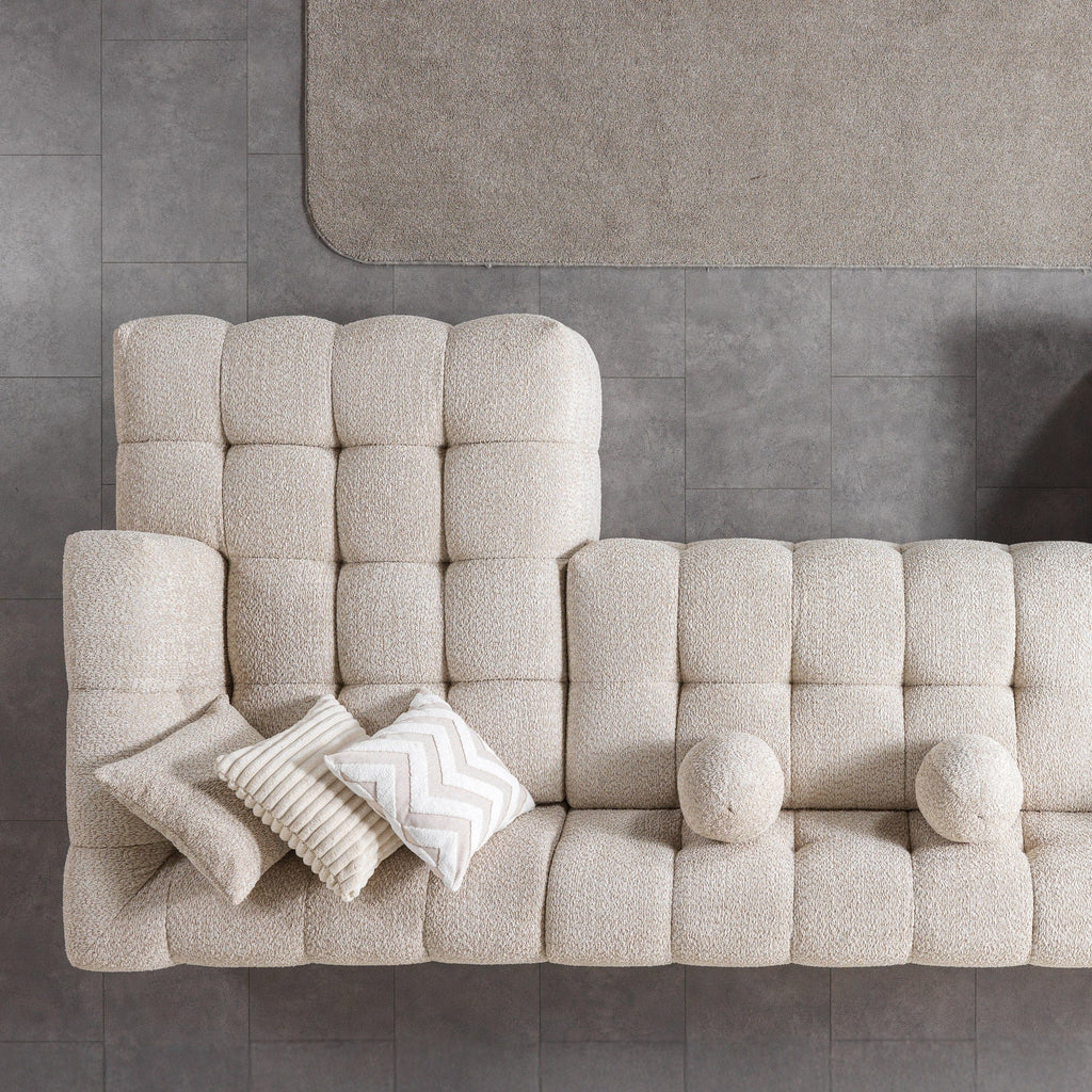 Beige sectional sofa with cushions on a gray floor