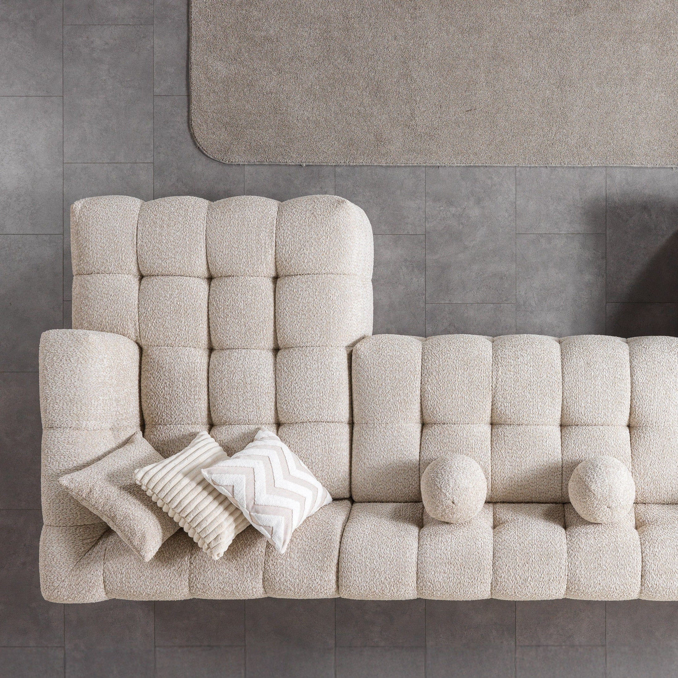 Beige sectional sofa with cushions on a gray floor