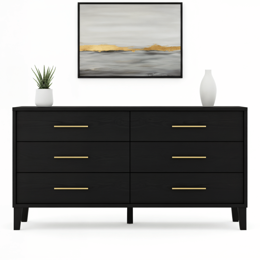 Black dresser with gold handles in a room setting with a painting and plants.
