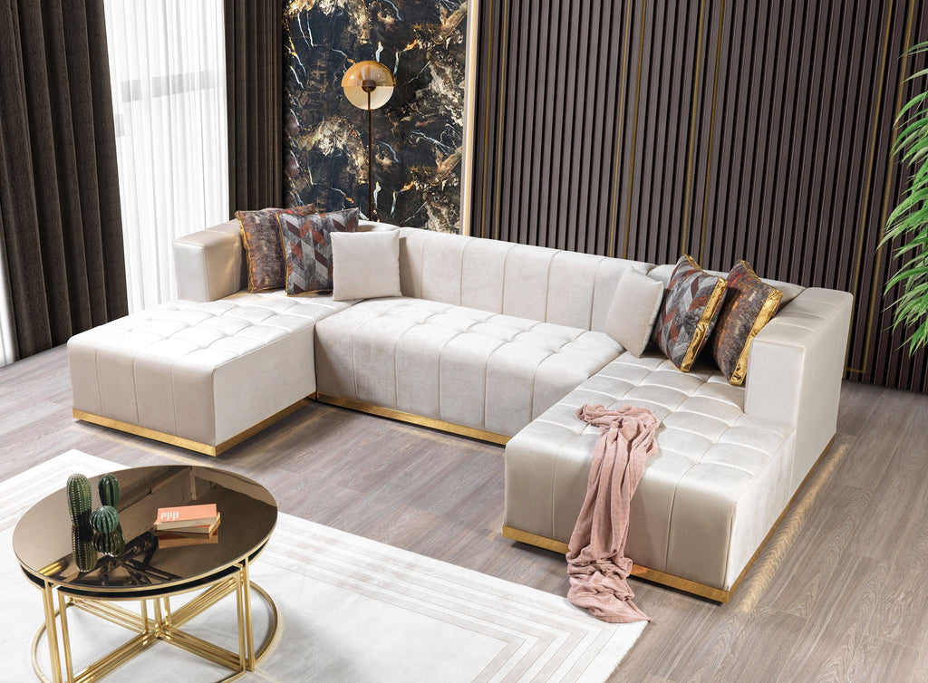 Modern living room with a white sectional sofa, gold coffee table, and decorative elements.