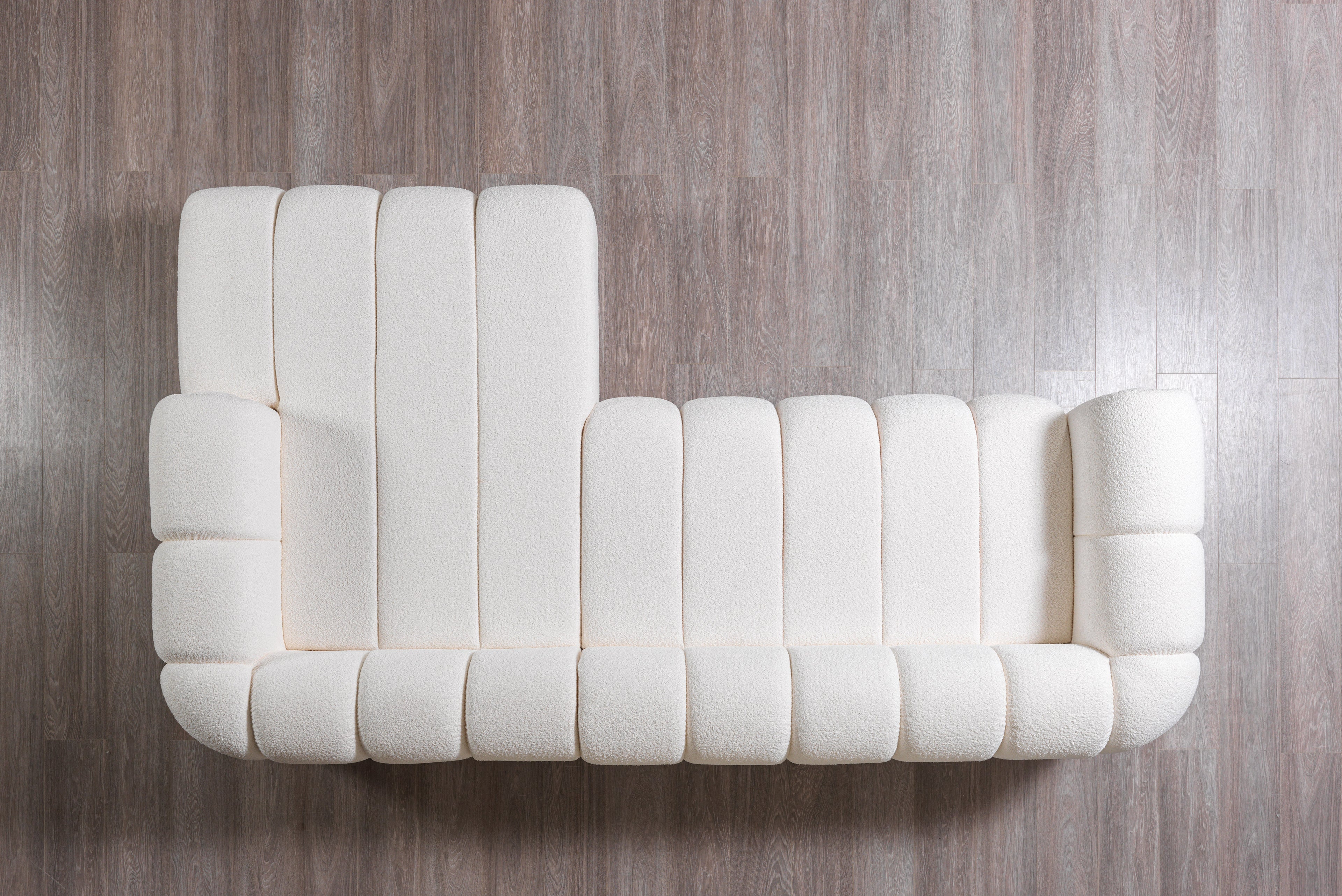 White tufted sofa on a wooden floor