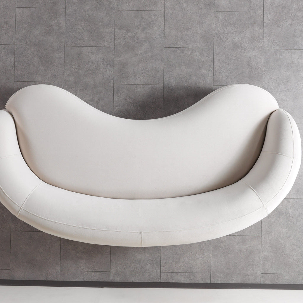 Modern white sofa against a gray tiled wall