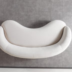 Modern white sofa against a gray tiled wall