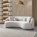 Modern beige sofa in a stylish living room with shelves and a rug.
