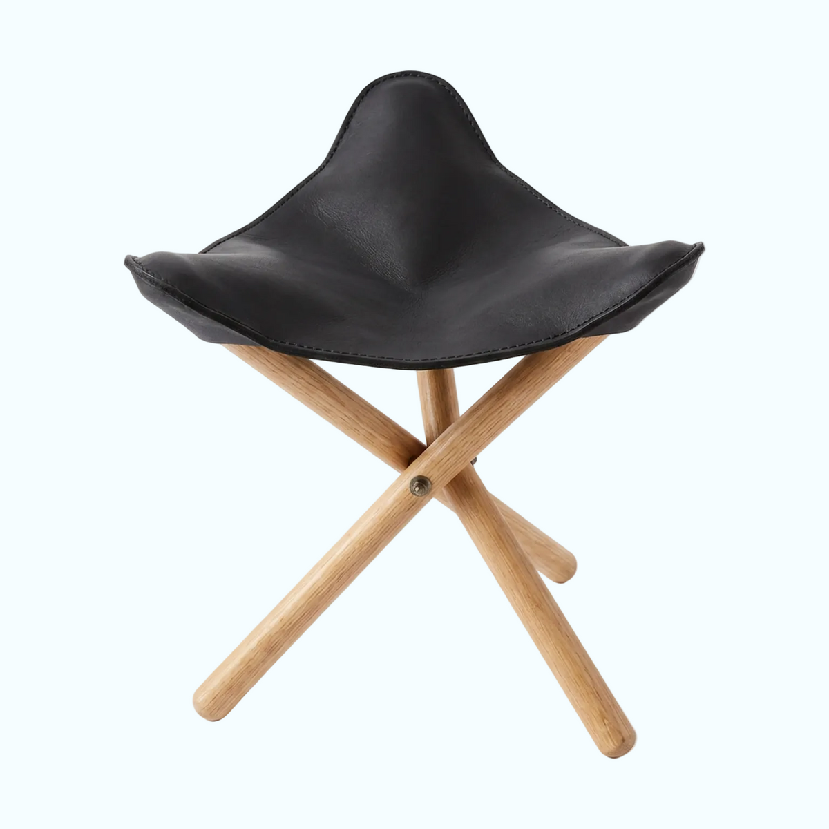A compact folding stool with a black faux-leather seat and light natural wood legs, shown on a clean white background.