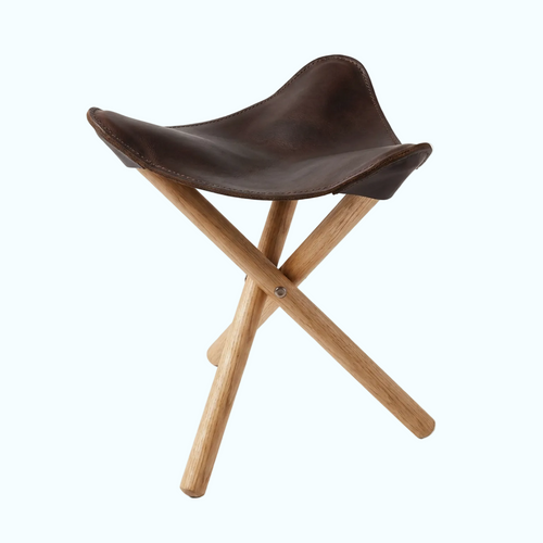 A folding stool with a dark brown leather seat and light natural wood legs, shown on a clean white background.